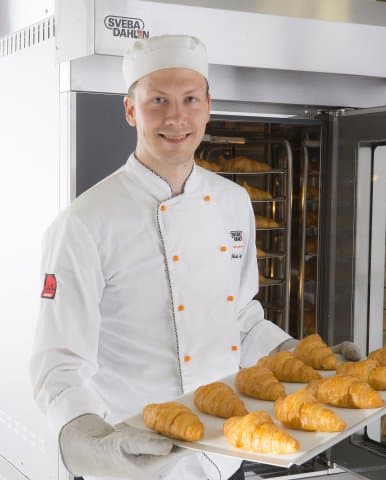 Baker baking croissants using Sveba Dahlen S-series Mini Rack Bakers Oven